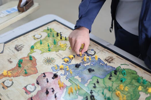Close-up of a hand playing a strategic board game on a colorful map.
