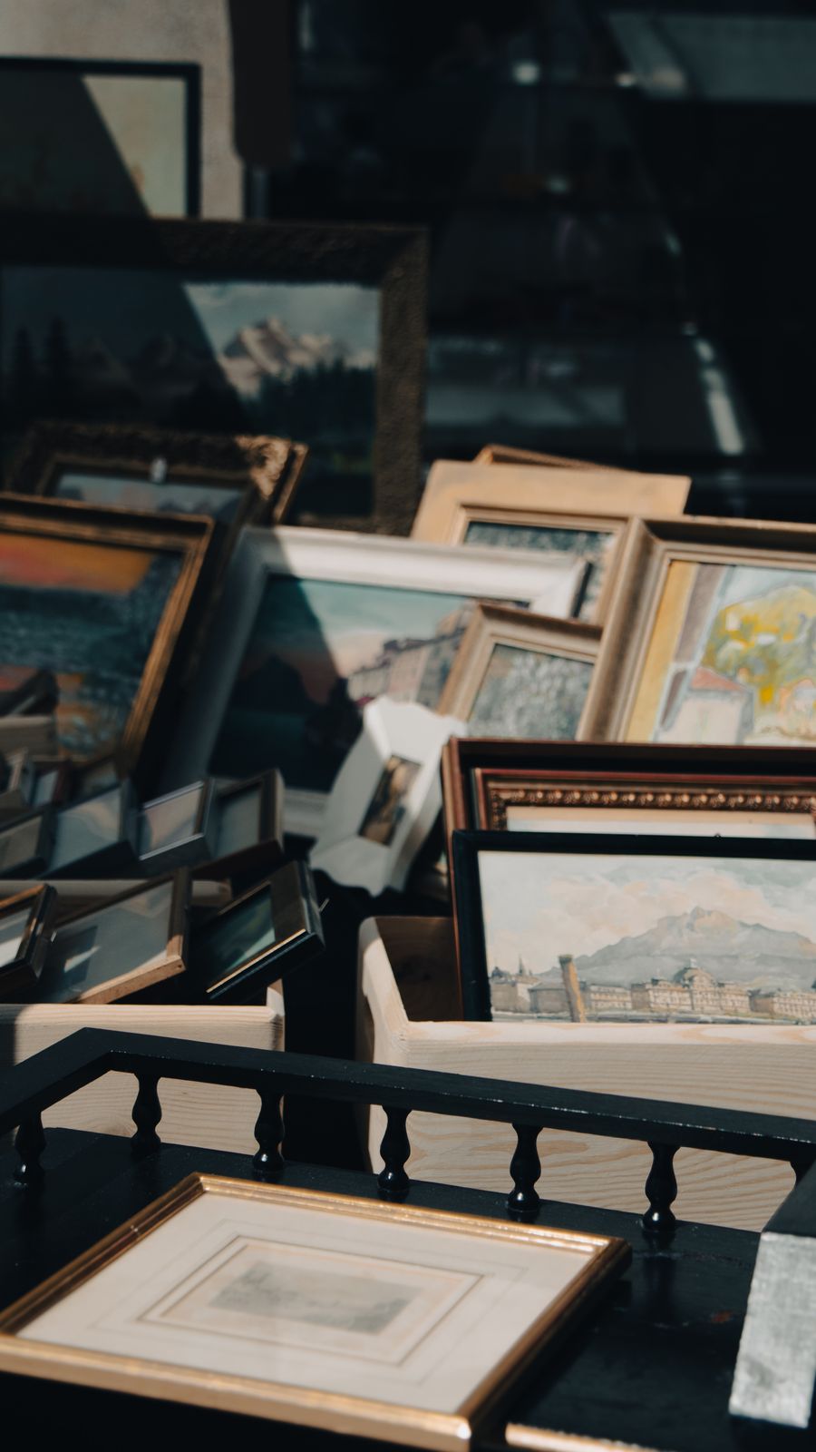 A stack of framed paintings in a workshop