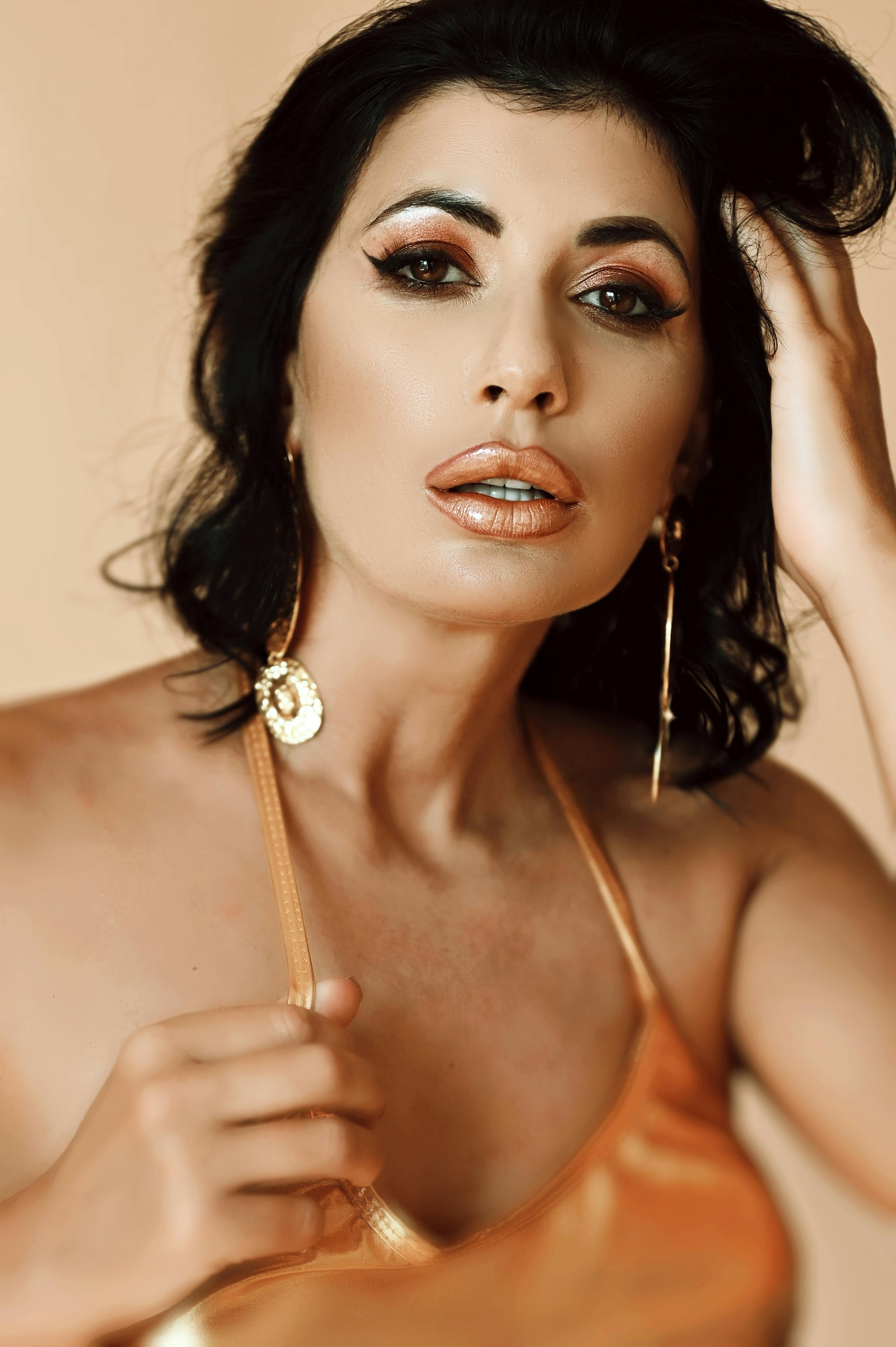 Close-up of a glamorous woman with elegant makeup, striking earrings, and luxurious style. Ideal for fashion and beauty themes.