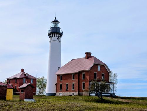 Free Scenic view of a historic lighthouse and buildings on Michigan's Lake Superior shores. Stock Photo