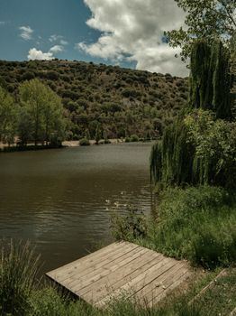 Peaceful lakeside view with lush greenery in Soria, Castilla y León, Spain.