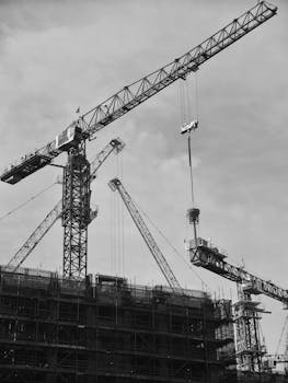 Black and white image of cranes at a Singapore construction site.