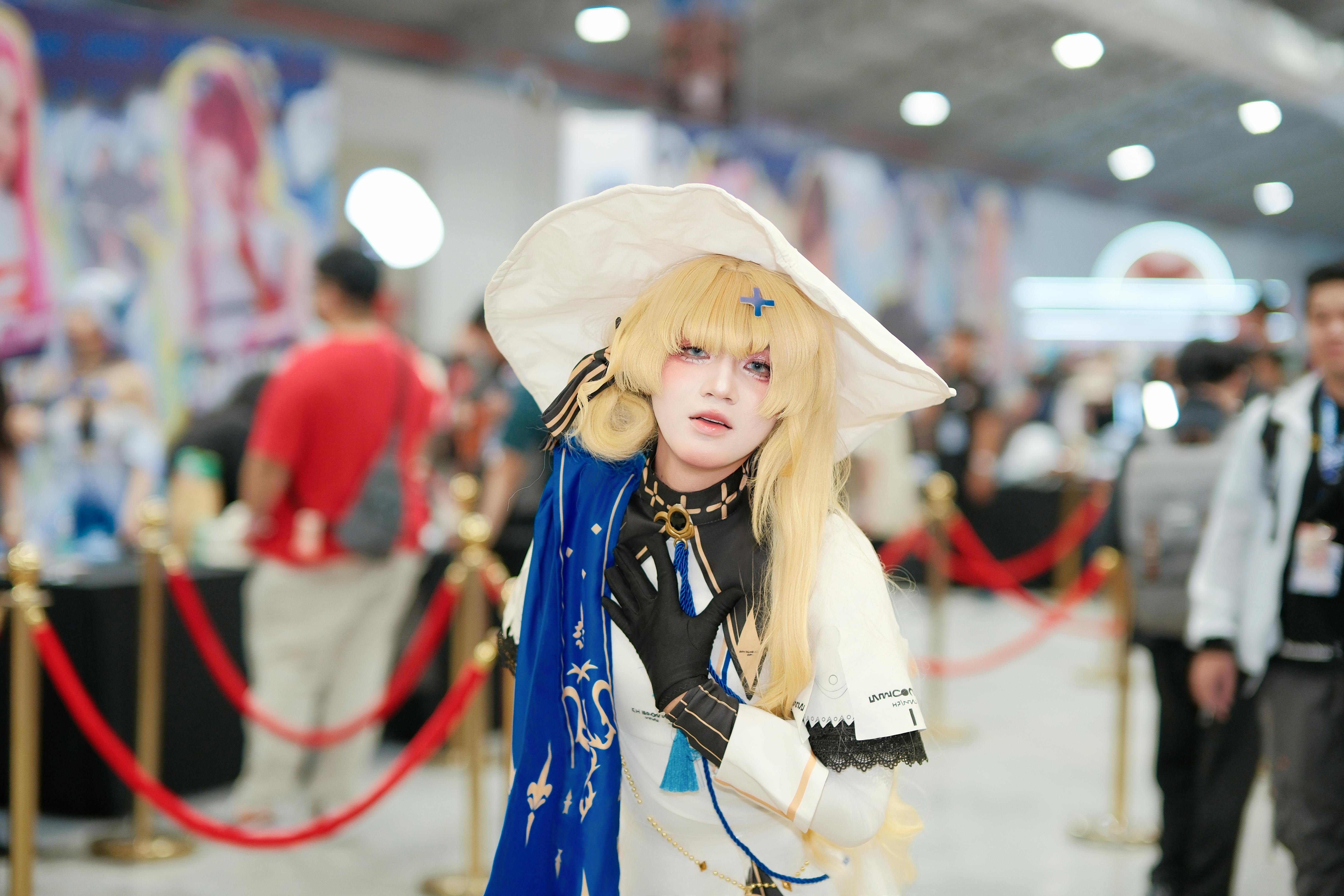 Cosplayer in detailed costume at a bustling comic convention.