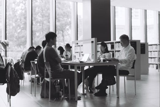 Students studying together in a modern library setting, focusing on coursework.