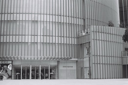 Contemporary building facade with luxury boutique entrances under a sleek metallic design.