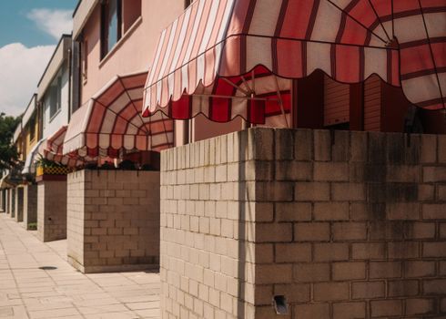 A scenic view of a row of colorful buildings featuring striped awnings.