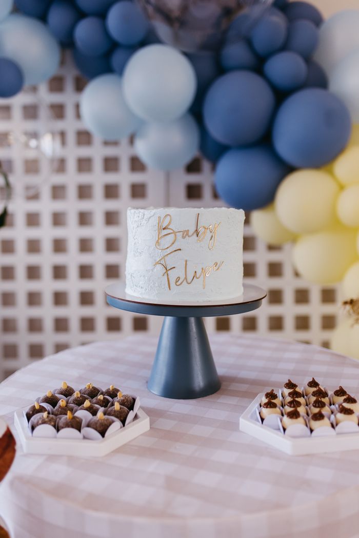 Baby shower cake framed by soft blue balloons