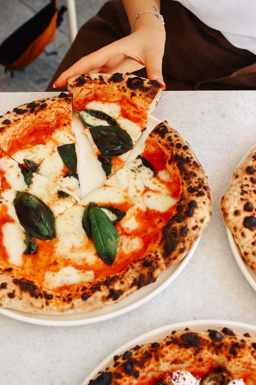 Free Tasty Margherita pizza topped with fresh basil and mozzarella, ready to eat. Stock Photo