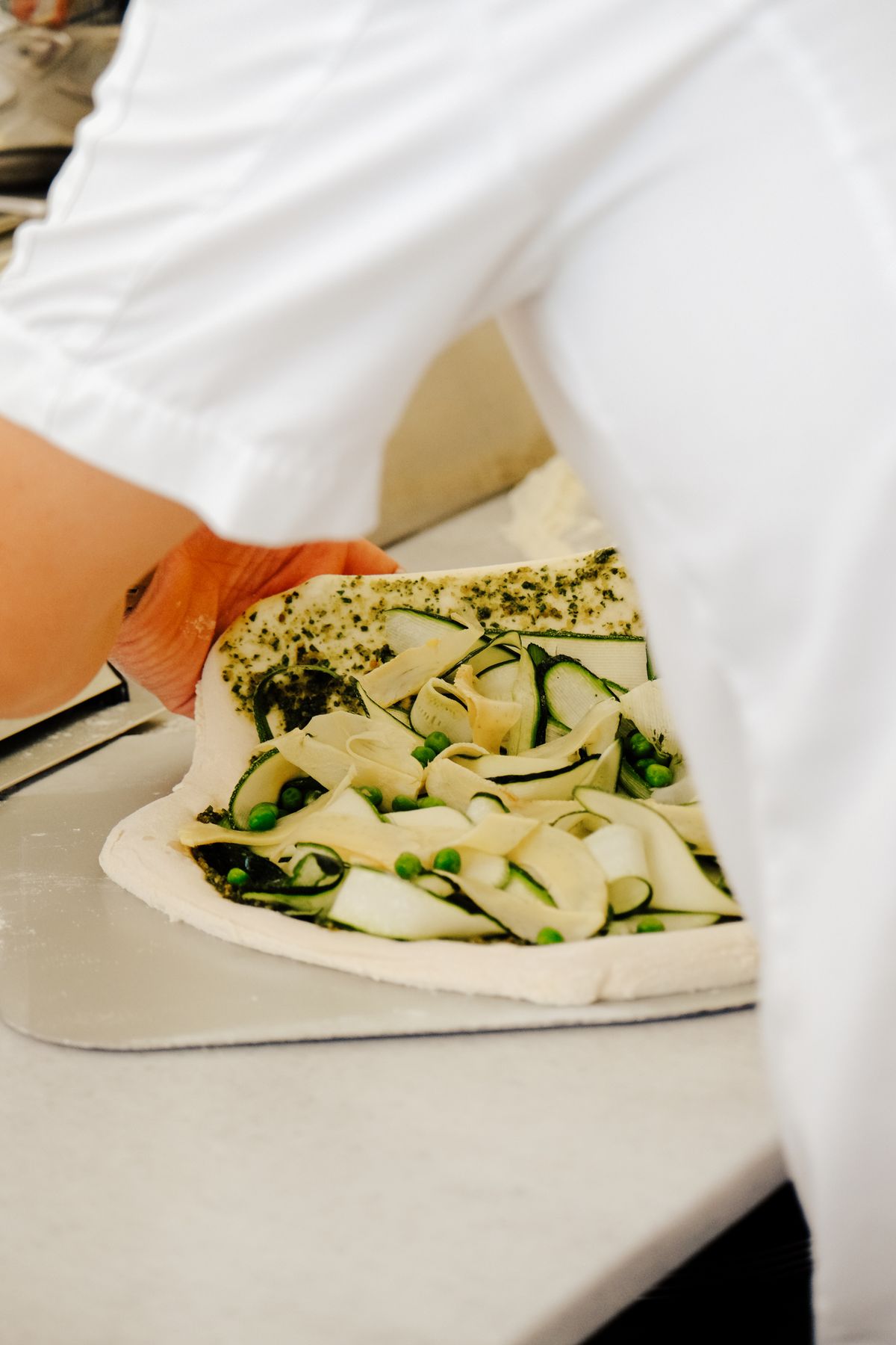 Chef preparing a vegetarian pizza