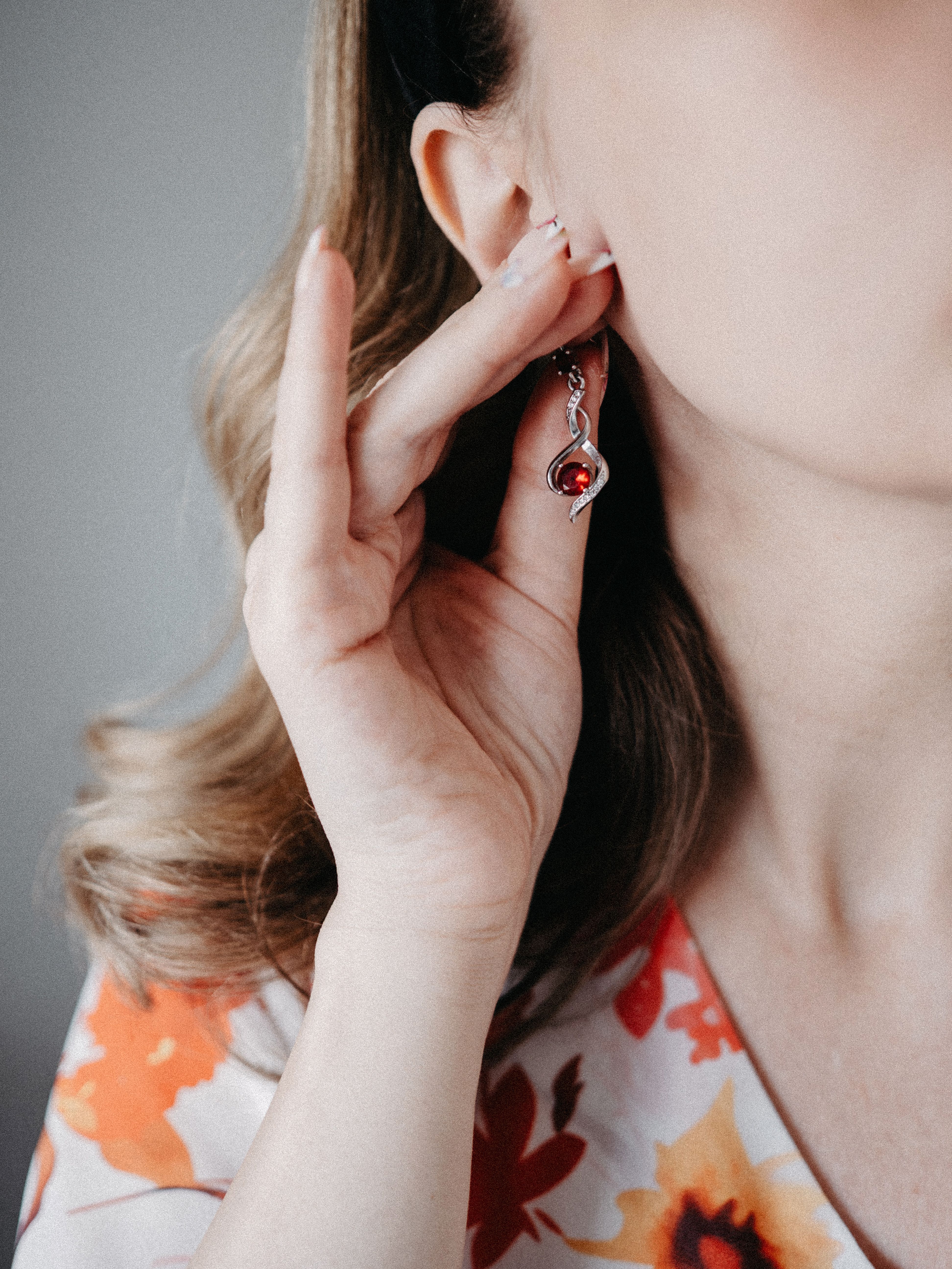 Close-up of a woman adjusting a stylish earring, showcasing her elegant fashion sense.