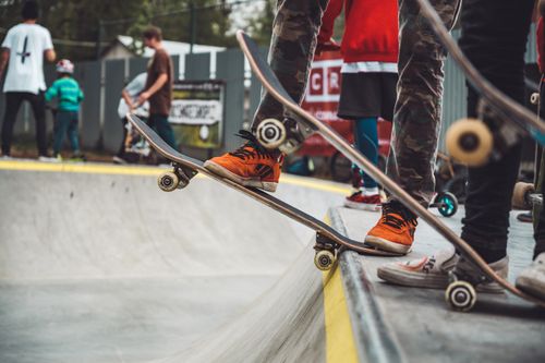 Free Kids and teens skateboarding at a lively outdoor skatepark, showcasing urban street culture and style. Stock Photo