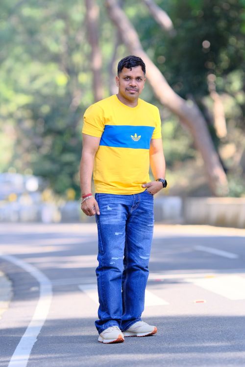 Free Man in casual outfit walks outdoors on a sunny day, showcasing a relaxed lifestyle. Stock Photo