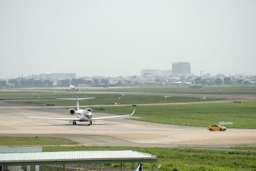 Free A private jet taxiing on the runway at an airport with a distant cityscape. Stock Photo
