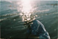 宁静的海滩上，阳光反射在水面上，形成了抽象的图案