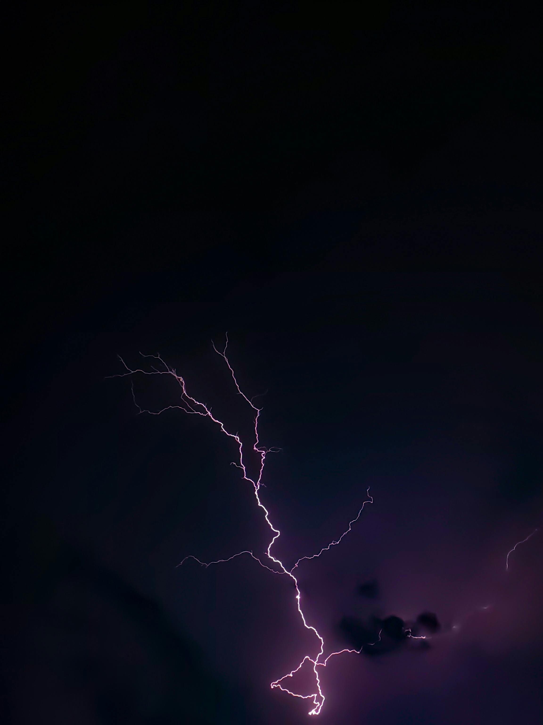 De franc Un llamp viu il·lumina el cel nocturn, capturant el poder brut de la natura. Foto d'estoc