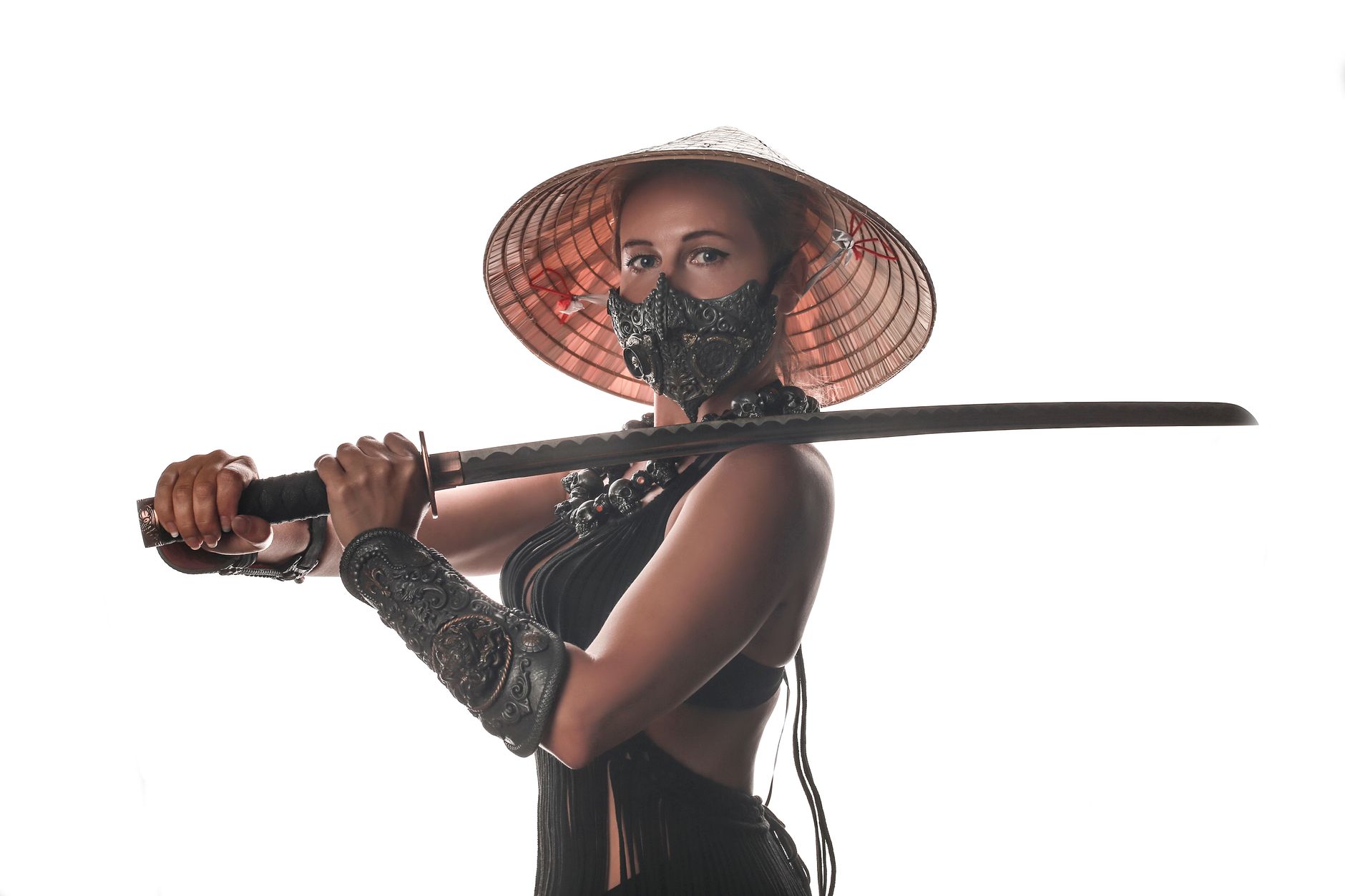 A female warrior holding a katana sword, wearing traditional armor and a straw hat against a white backdrop.