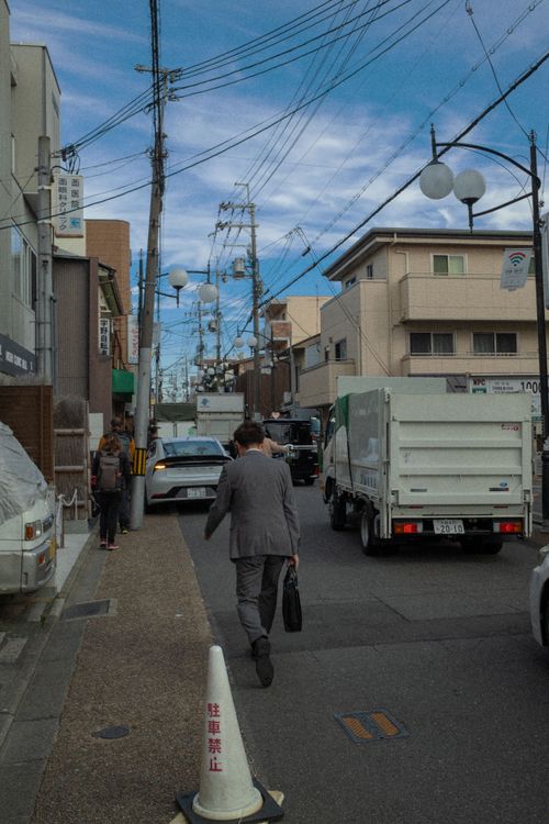 Free Busy urban street featuring pedestrians and various vehicles under a blue sky. Stock Photo