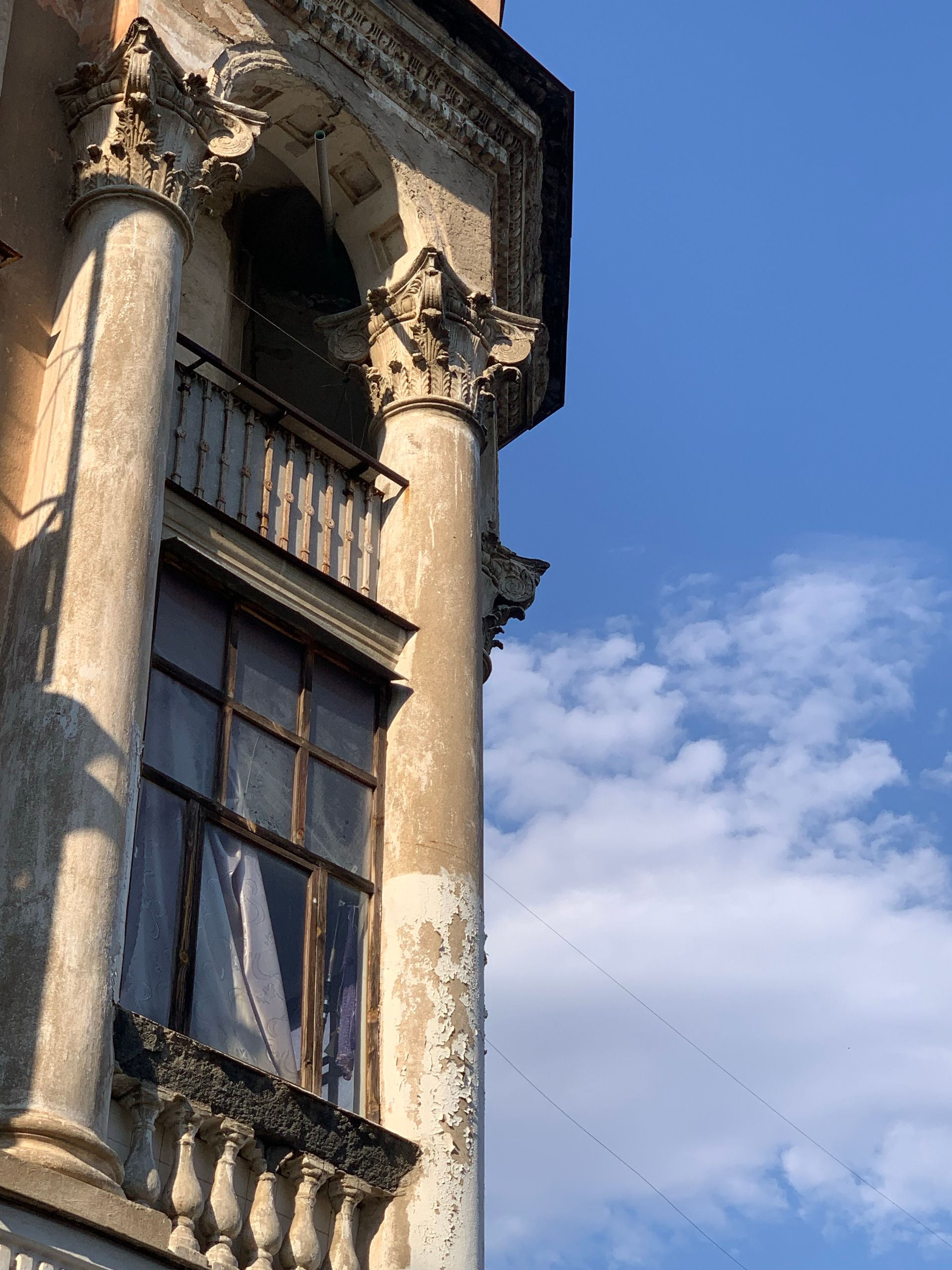 Fachada clásica con columnas y molduras de piedra contra un cielo despejado