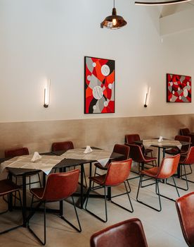 Chic industrial-style cafe in São Paulo with modern furnishings and abstract art.