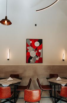Elegant modern cafe interior with industrial lighting and abstract art, Guarulhos, São Paulo.