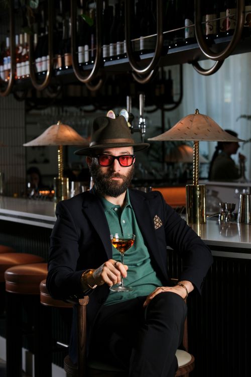 Free Portrait of a fashionable man enjoying a cocktail in a chic London bar. Stock Photo