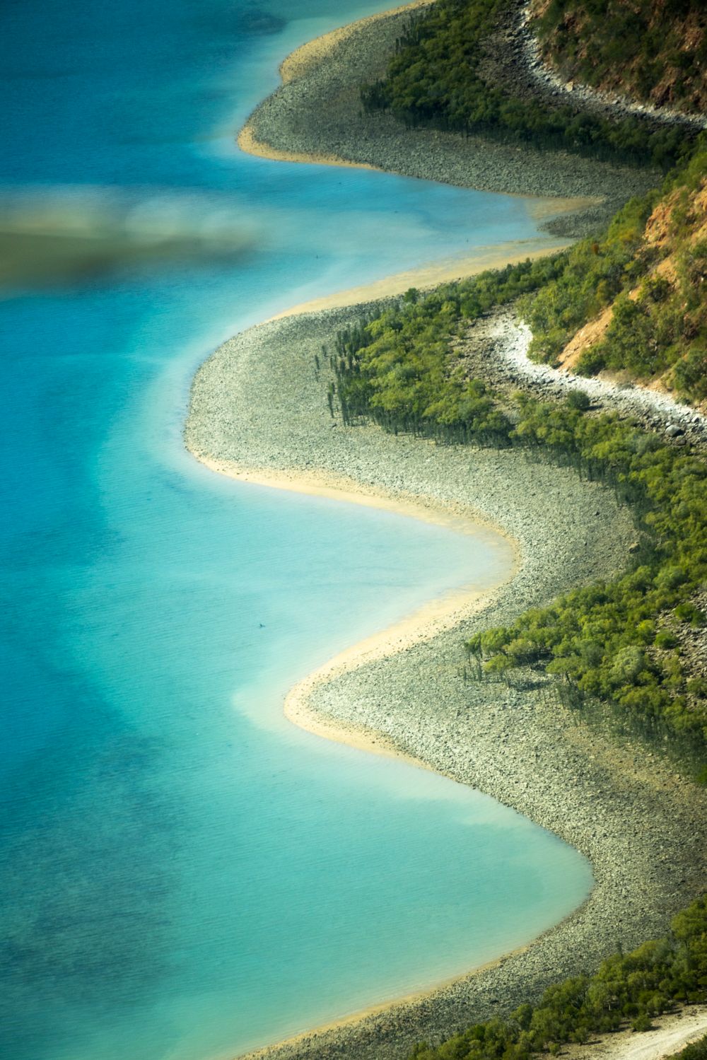 Costa serpenteante del Kimberley con aguas turquesa y vegetación rojiza vista desde el aire