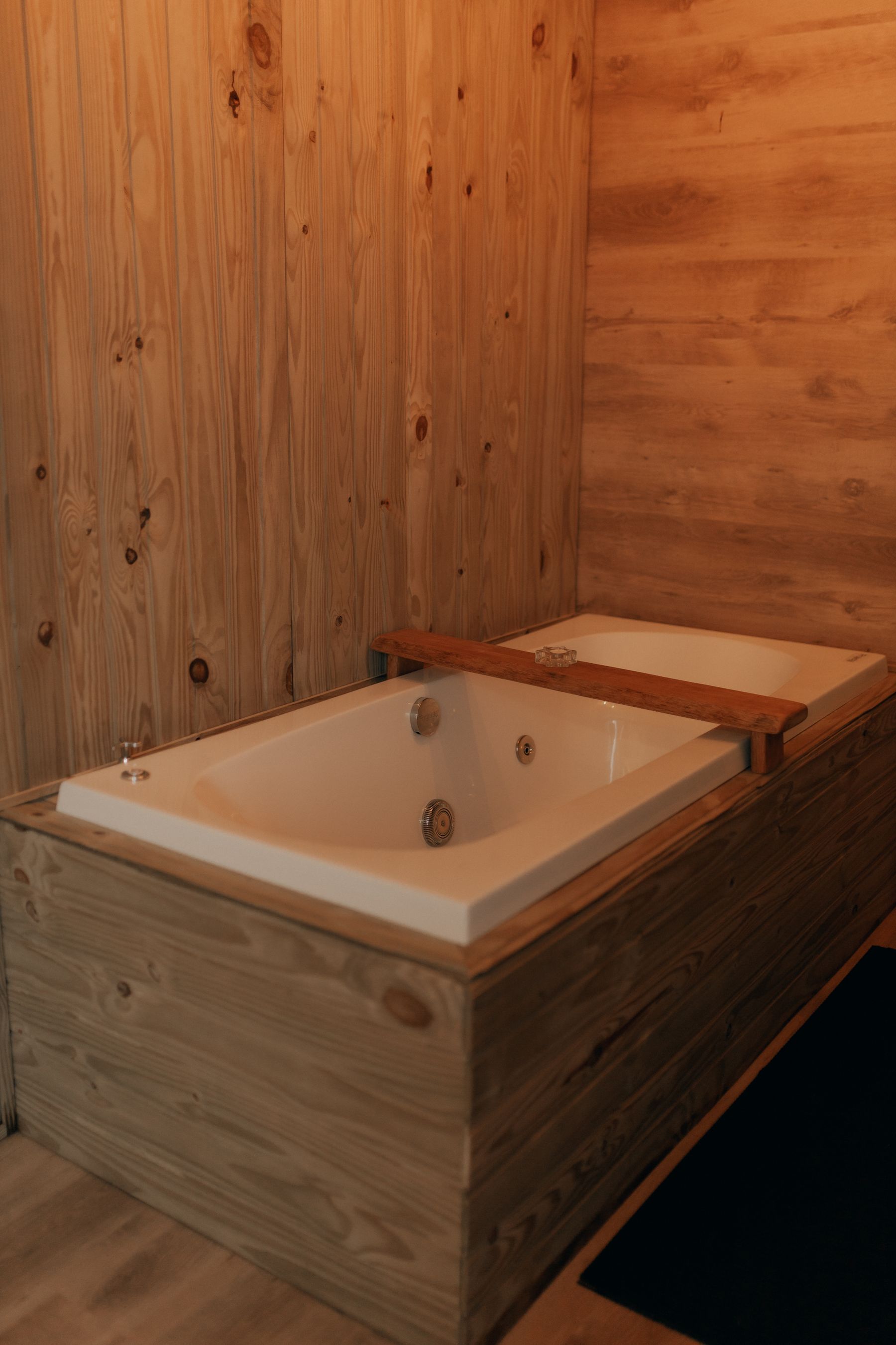 Warm timber bathing area with wooden bathtub and paneling