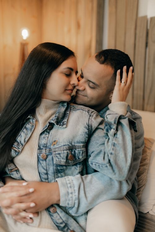 Free A couple shares an intimate moment indoors, exuding warmth and love in soft lighting. Stock Photo