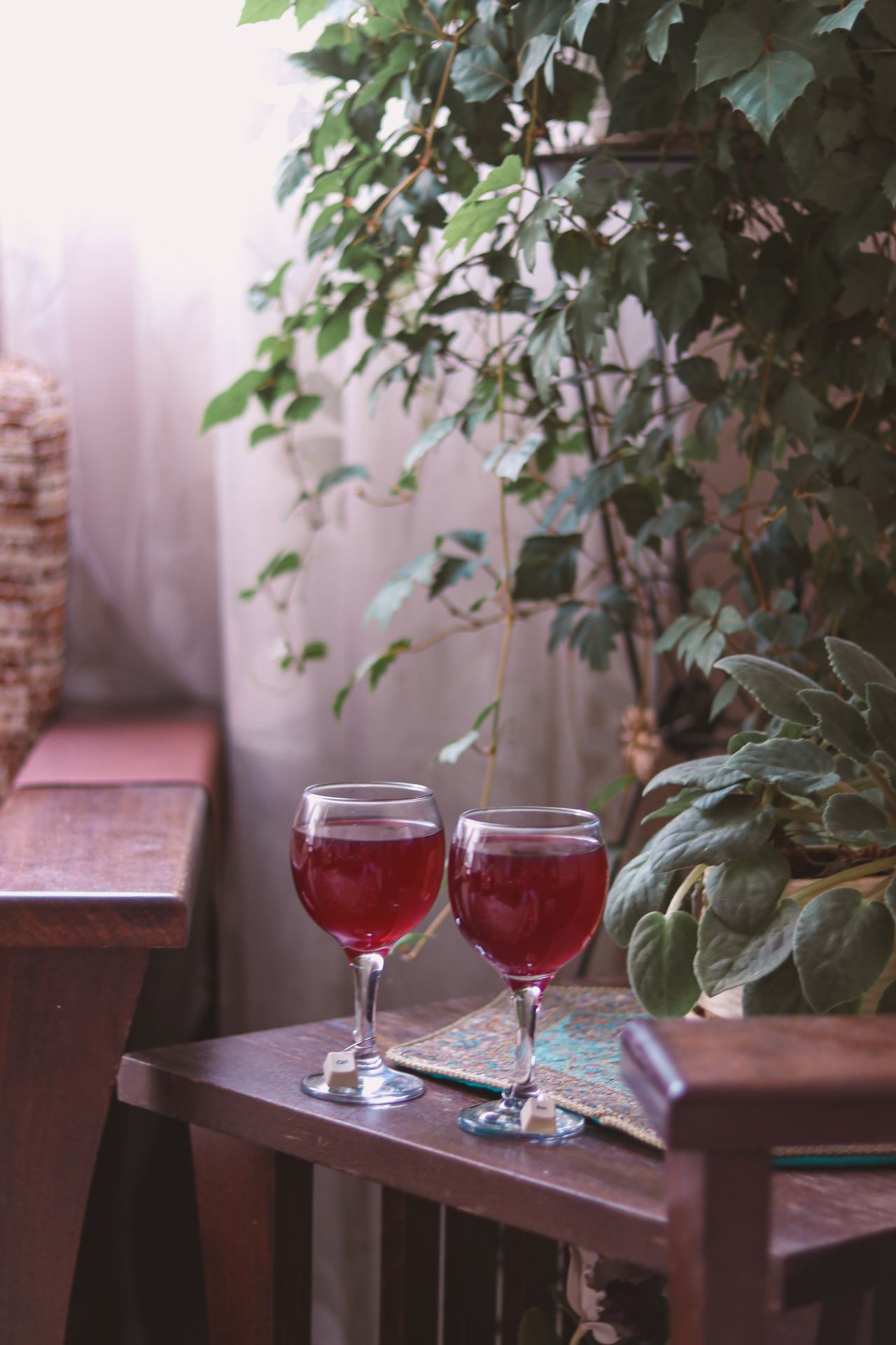 red-and-blue-colored-glassware Wine glasses and greenery arranged on an indoor table