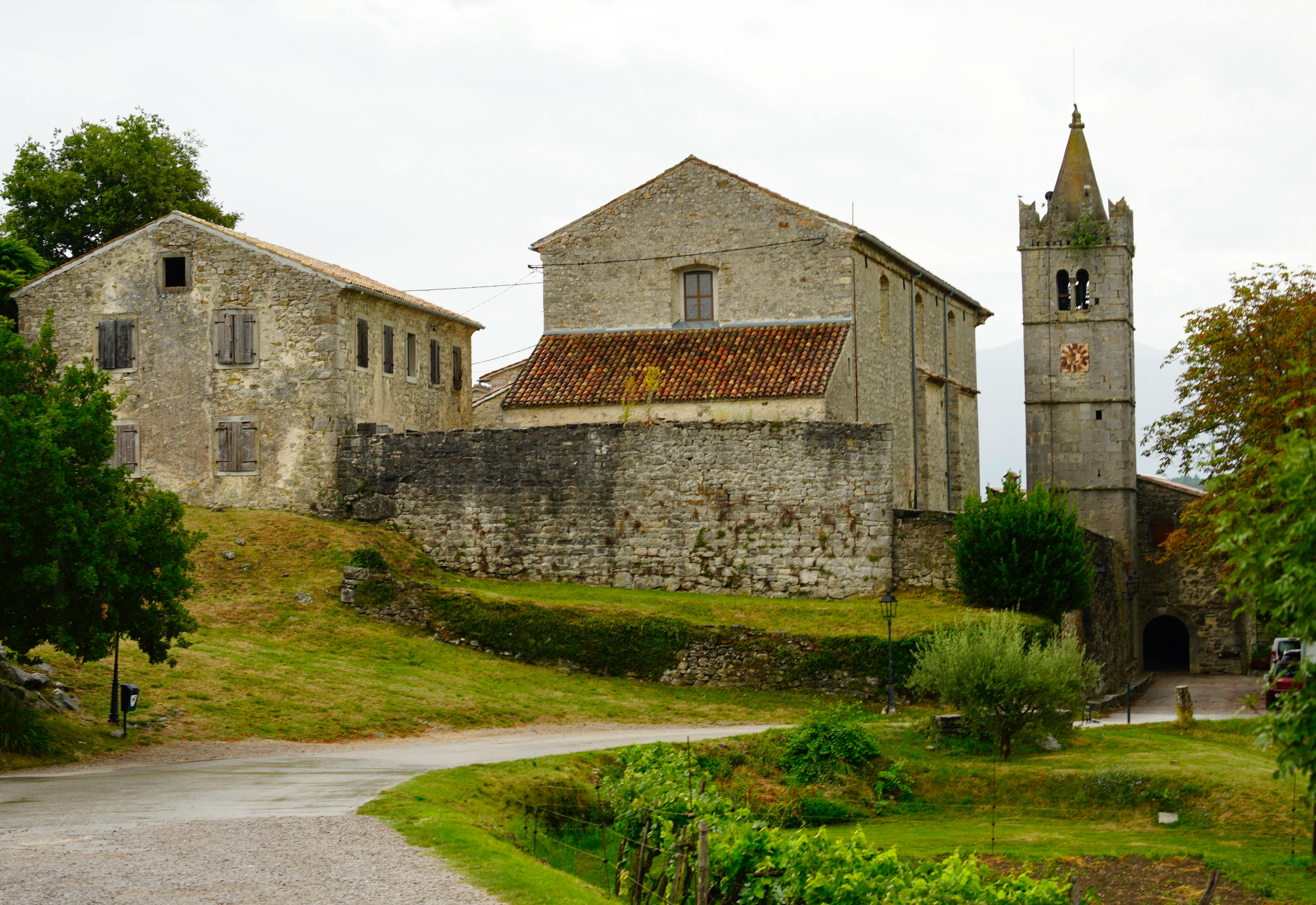 Hum Croatia smallest town medieval stone walls and bell tower at sunset with terracotta rooftops in Istrian countryside