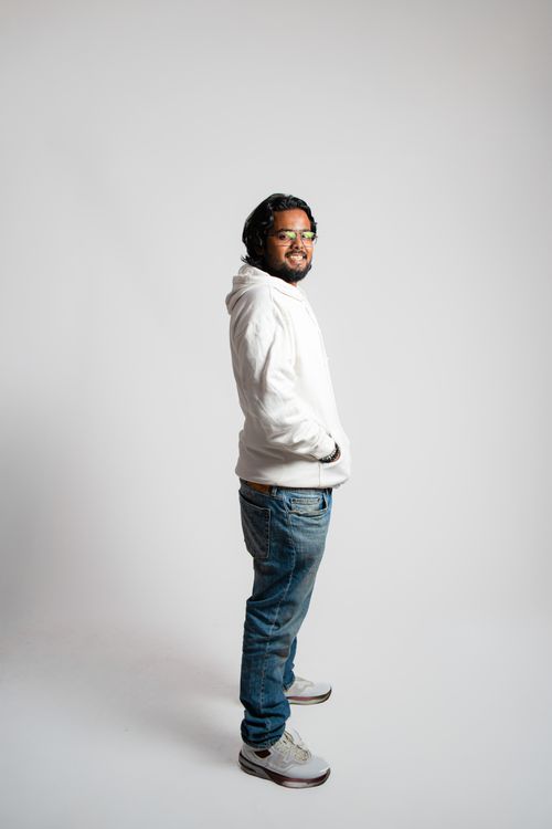 Studio side profile of a man in a bone hoodie and indigo jeans — photo by Karan Mridha on Pexels