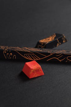 Stylish keycap set with intricate designs, highlighting the ESC key, on a dark textured surface.