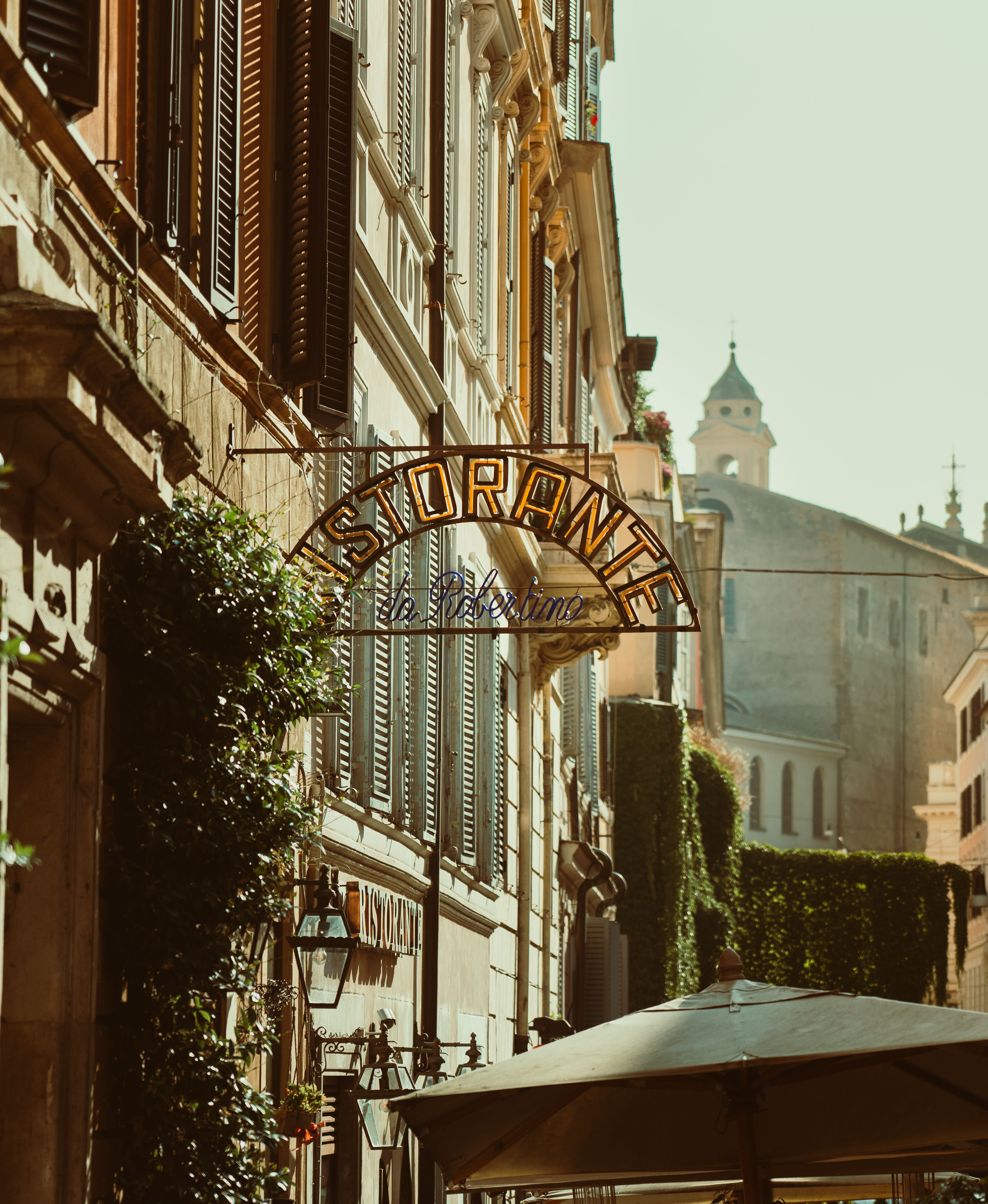 Quaint street view in Rome featuring a classic 'Ristorante' sign and historic architecture.