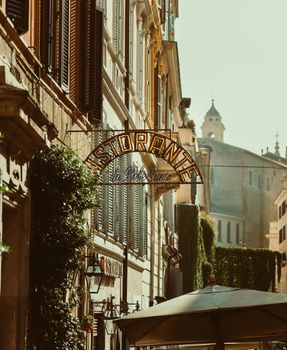 Quaint street view in Rome featuring a classic 'Ristorante' sign and historic architecture.