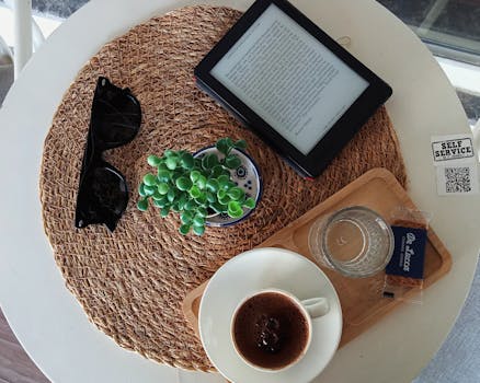 Top view of a cozy café table with an ebook, Turkish coffee, and succulent plant.