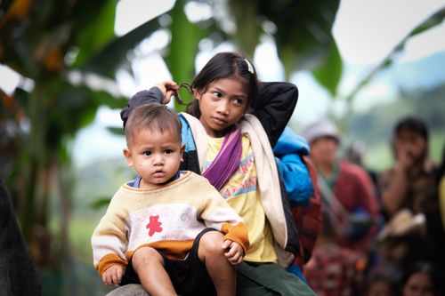 Free Two children outdoors in vibrant clothing, surrounded by nature. Candid moment captured. Stock Photo