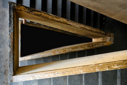 Top view of a triangular brutalist staircase in Vietnam, featuring a haunting play of light and shadow.