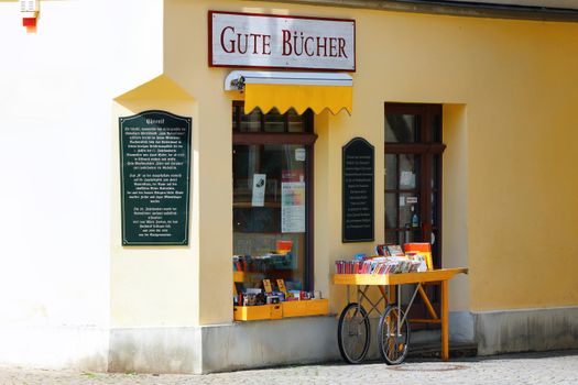 A quaint bookstore with an outdoor book display, showcasing 'Gute Bücher'. Perfect for book lovers.