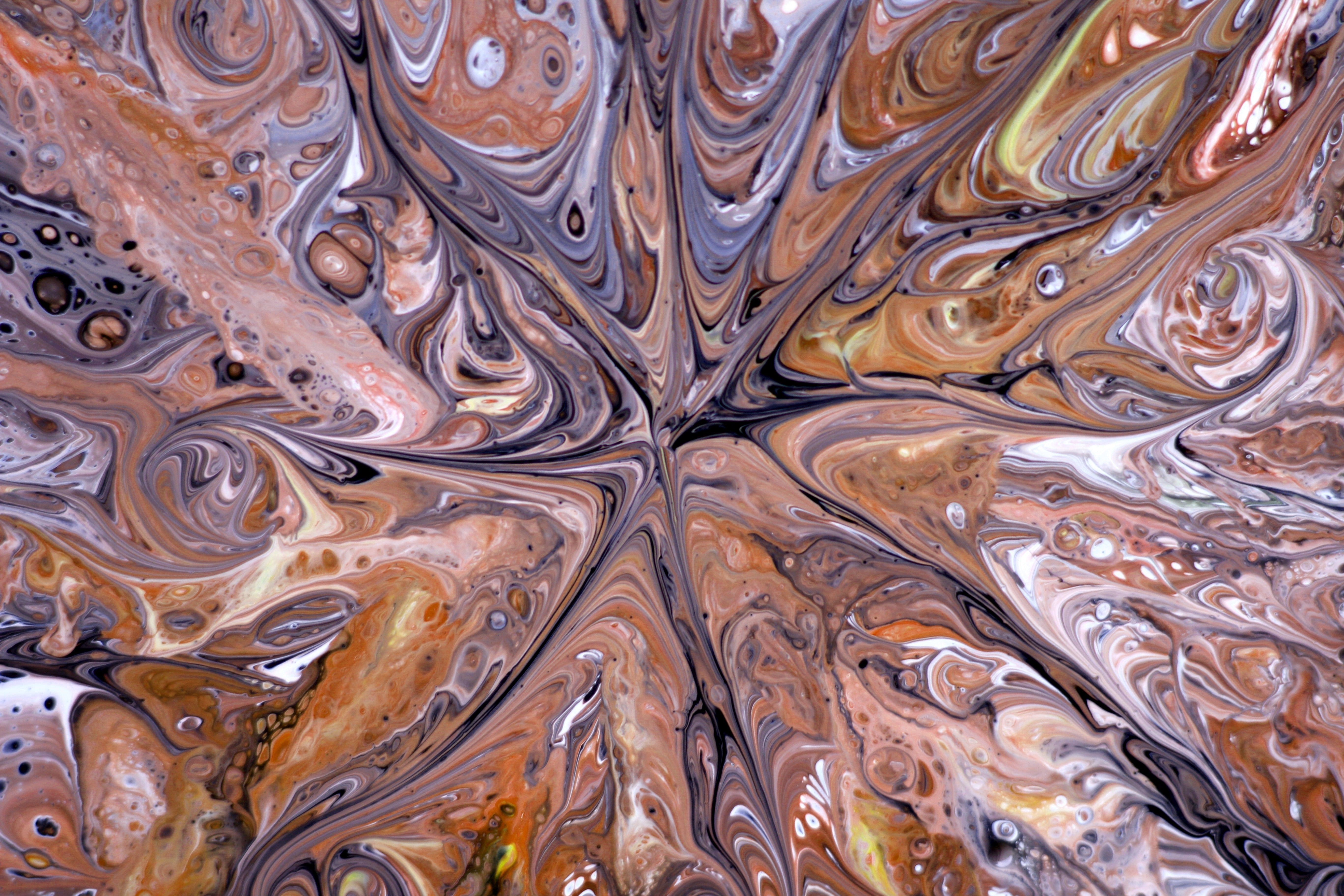 A close-up of abstract fluid art featuring swirling patterns in earthy tones, creating a mesmerizing visual effect.