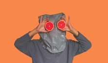 Person Covered With Plastic Bag on Head While Holding Sliced Blood Orange