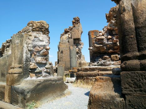Explore the ancient ruins under a clear blue sky, capturing historical architecture and timeless beauty.