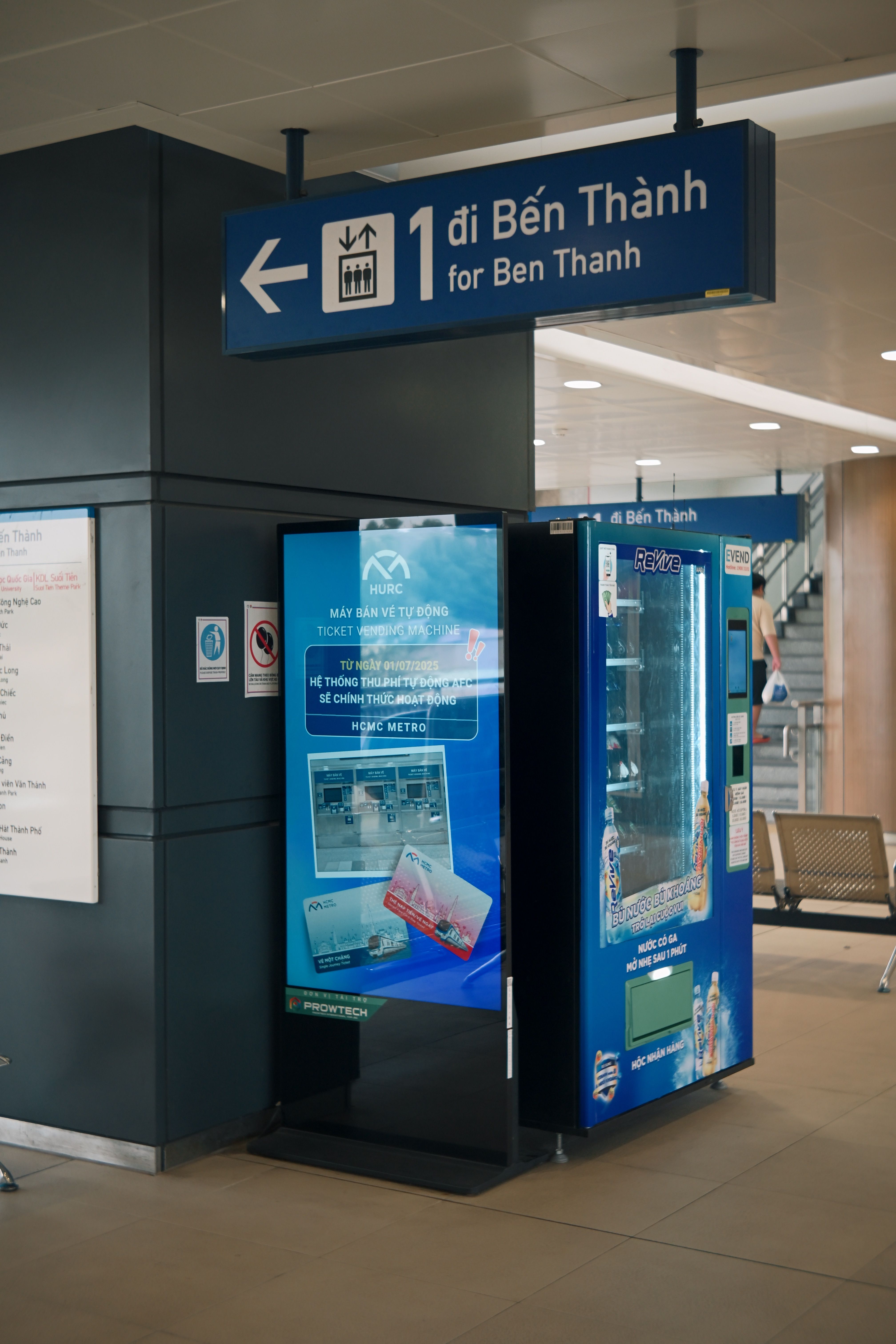 Inside Ben Thanh metro station with signage and vending machine.