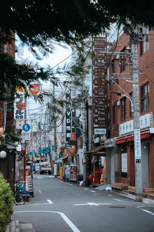 Free Quaint street view of a Japanese city with signs, shops, and urban architecture. Stock Photo