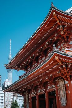 A scenic view of a traditional Japanese temple with Tokyo Skytree in the background, under a clear blue sky.