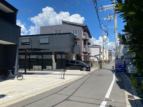 Sunny street in a Japanese neighborhood with modern residential buildings and a clear blue sky.