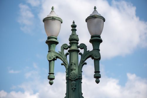 Free Detailed view of an ornate street lamp with a blue sky and clouds background in Belo Horizonte. Stock Photo