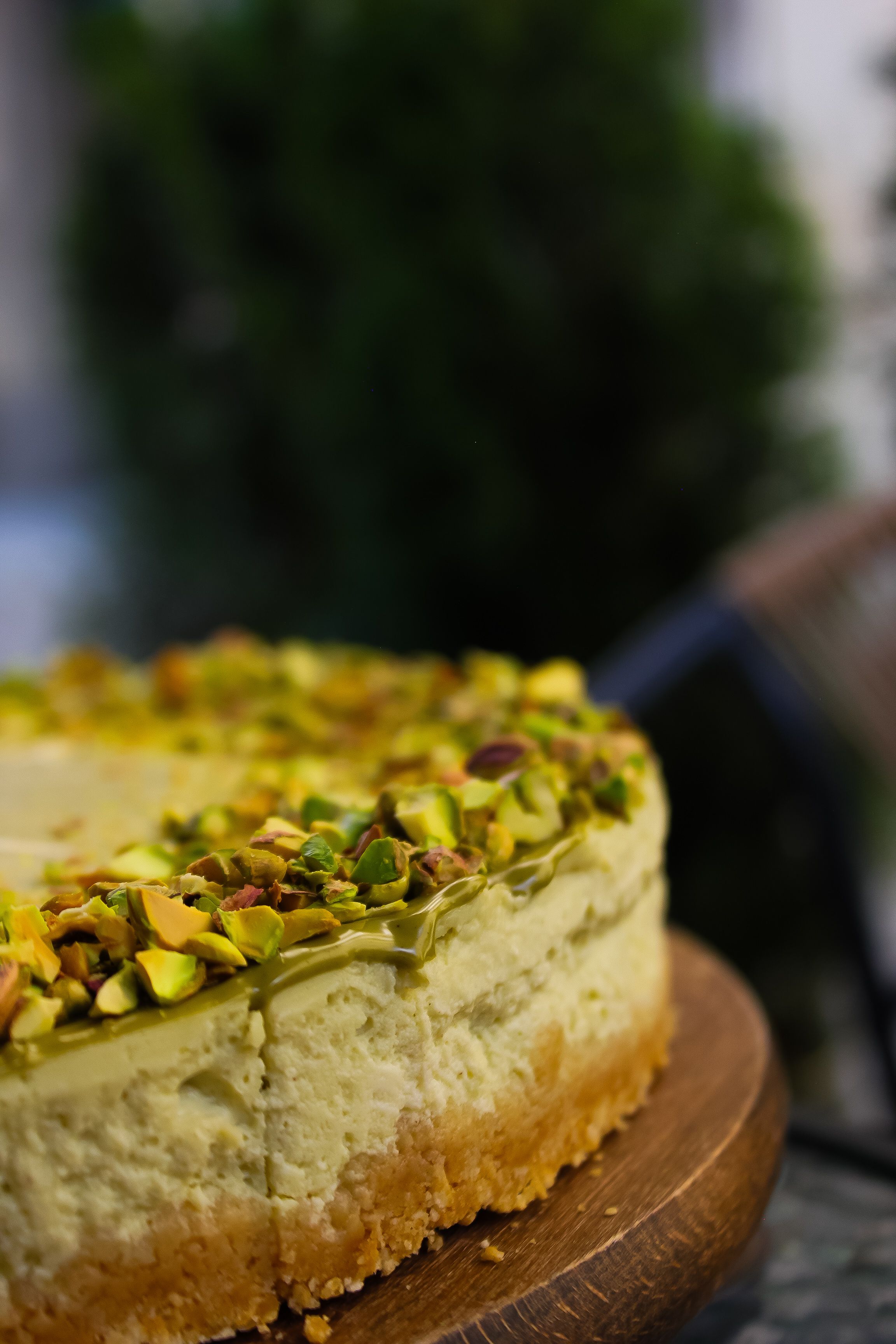 Delicious pistachio cheesecake on a wooden board, perfect for dessert lovers.