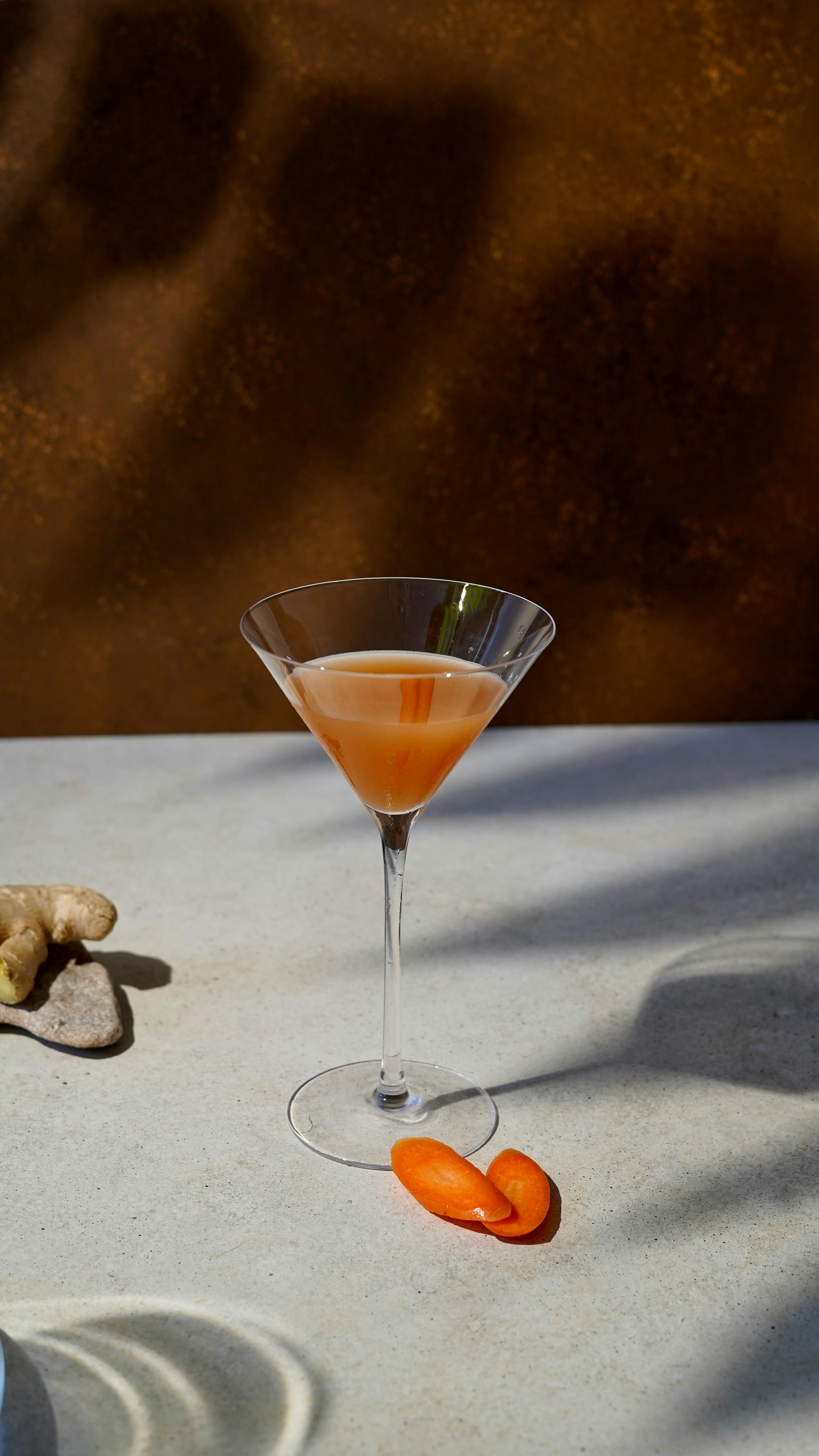 Sophisticated martini glass filled with a vibrant citrus cocktail on a stylish surface.