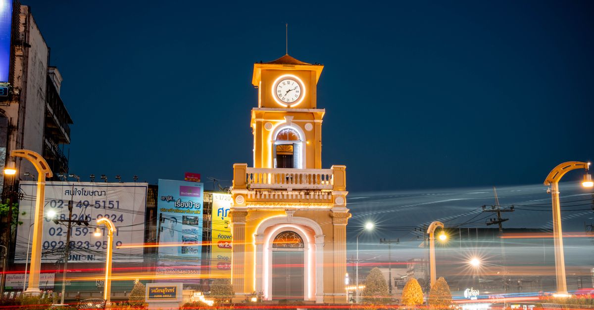 Night view of the illuminated Phuket Clock Tower with vibrant light trails