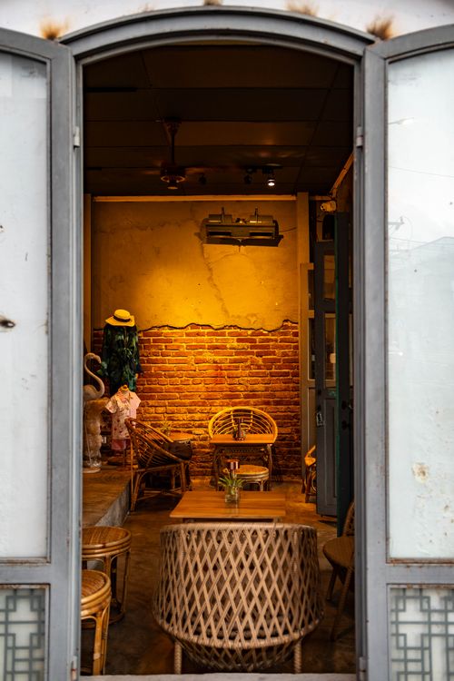 Free Warm and inviting rustic cafe interior featuring wicker furniture and exposed brick walls. Stock Photo